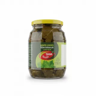Jar of Teeba grape leaves with yellow lid held in hand
