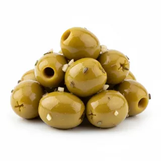 Close-up of plump green olives marinated with herbs and garlic in oil lose outside container without plate