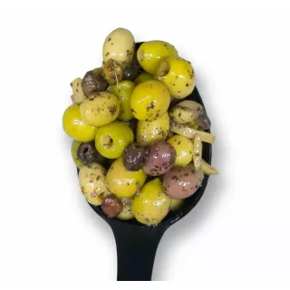 Mixed green olives marinated with herbs in oil with a black spoon