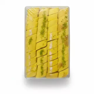 Clear plastic pack of yellow saffron-based Kak Candy with visible sliced nut pieces inside