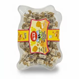 Clear plastic box containing individually wrapped milk honey toffee pieces