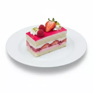 Single slice of Mixed Berry Celebration Cake on white plate topped with strawberries, raspberries and pistachios