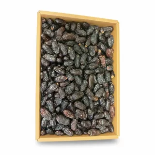 Close-up of dark, wrinkled Ajwa dates packed in a box