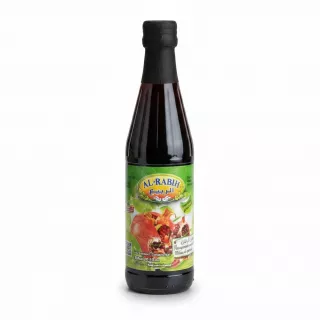 Bottle of Al-Rabih pomegranate molasses held in hand showing front label