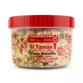 A 454g clear plastic tub of Al Yaman Halawa with whole pistachios from Lebanon, presented as a professional e-commerce product photo on a clean white background. The red lid is visible at the top. The label is sharp, clearly showing all text and branding, including "Al Yaman Halawa Pistachio," "Produced in Lebanon," and contact details. PRODUCT TITLE: Al Yaman Halawa Pistachio PRODUCT: A professional, studio-quality e-commerce photograph of the Al Yaman Halawa Pistachio 454g tub, as shown in image_0.png, but centered and filling approximately 85% of the square (1:1 aspect ratio) frame. All elements of the messy store background (floors, feet, hands, shelves, products, price tags) are completely removed, replaced by a flawless, seamless pure white studio background. The product, a clear plastic tub with a red ribbed screw-top lid, is isolated. The contents, a dense, creamy-looking Halawa mixture densely studded with whole, rich green pistachios, are perfectly clear and sharp, with all surface imperfections on the plastic tub (fingerprints, dust, etc.) digitally cleaned. The front label from image_0.png is kept, but rendered with razor-sharp clarity, ensuring every detail is perfectly legible, including: the title "Al Yaman" in large red script with "Founder & The Original" below it; "Halawa Pistachio" clearly written; the Producer "Produced in Lebanon" and contact numbers ("Tel 08/930796", "Tel/Fax 07/222580"); and other branding logos ("ACERTA" certification, "The Original" with a chef-like icon). The red lid at the top is pristine. The composition is head-on. The lighting is soft and even professional studio quality, designed to make the pistachios pop and make all text perfectly readable. The product casts a very subtle, soft, symmetrical contact shadow directly beneath it, balanced on both sides, grounding it without being obtrusive. All specific text, numbers, and facts from the label in image_0.png are preserved exactly, just made clearer. All visible labels, price stickers, and tags are removed from the background. The final image is sharp-focus throughout.