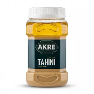 A 1700g plastic jar of AKRE Tahini, an authentic sesame spread, featuring its green and blue label, with a ribbed white cap, displayed on a clean white background with a soft, even shadow.