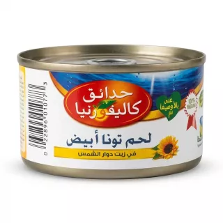 A 1:1 professional e-commerce product photograph of a centered tin of California Garden Light Meat Tuna in Sunflower Oil, featuring its prominent Arabic language front label. The metallic can with its detailed red and white label, featuring a sunflower and Arabic text "لحم تونا أبيض في زيت دوار الشمس" (Light Meat Tuna in Sunflower Oil), is isolation on a pure white background with soft, even studio lighting and subtle, balanced shadows. PRODUCT TITLE: California Garden Tuna Light Meat - Halal, Sunflower Oil PRODUCT: Arabic front label of California Garden Light Meat Tuna tin PREFERENCES: - Aspect ratio: 1:1 This is a high-resolution, professional studio photograph of a single tin of California Garden Light Meat Tuna, derived from the original image. The tin has been meticulously isolated, removing the person’s hand, the grocery store shelves, other products, and the floor, placing the can on a pure, seamless white background. The product is precisely centered and occupies approximately 85% of the frame, filling the 1:1 square canvas. Professional studio lighting, evenly distributed, illuminates the product from the front, highlighting the metallic texture of the tin’s lid and base. The focus is critically sharp across the entire can and its label. All external tags, price labels, and imperfections have been removed. The can’s colorful label (the specific red, blue, and white pattern with the central red oval) is clean and perfectly preserved, with all Arabic text and graphics rendered with absolute clarity. The text “لحم تونا أبيض في زيت دوار الشمس” (Light Meat Tuna in Sunflower Oil), the red “California Garden” brand oval with its tree logo, and the sunflower graphic are crisp and legible. The side with the barcode (from the left of the original can) is integrated smoothly and clearly. A subtle, soft, evenly distributed contact shadow is cast beneath and symmetrically on both sides of the product, grounding it to the white surface without dominating. All factual product details (can shape, label design, specific text, colors, texture) remain identical to the original, only cleaned and presented professionally. The overall impression is one of high-quality food product presentation.