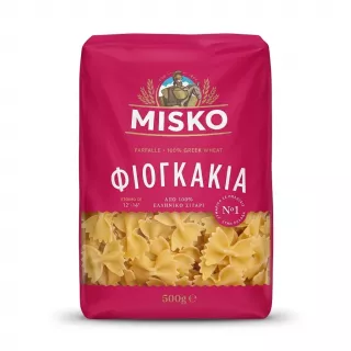 A 1:1 professional e-commerce product photograph showing a single 500g package of Misko Farfalle pasta against a clean, white background. The bright magenta package is centered, featuring clear Greek and English text, with a transparent window at the bottom revealing the bow-tie-shaped pasta. There are no tags or labels, and the lighting is even and sharp with a soft, symmetrical shadow.