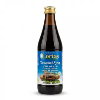 Enhanced Cortas Tamarind Syrup 600ml bottle with gold cap, held in hand in a grocery store aisle