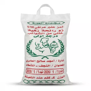 A 5kg white woven sack of Majed Premium Iraqi Rice. The front features red and green Arabic text detailing the product's origin and quality, a green chef logo within a wheat wreath, and clear production and expiry dates, presented in a clean e-commerce studio shot.
