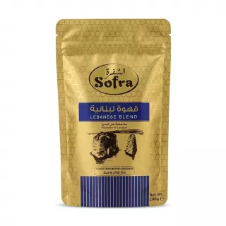 A 200g gold-foil stand-up pouch of Sofra Lebanese Blend Coffee with Medium Cardamom. The pack features Arabic text, a landscape illustration, and states "Roasted in London".