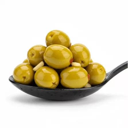 Close up of shiny marinated green olives in a spoon