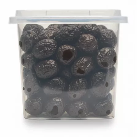 Close-up view of dried natural black olives inside transparent container