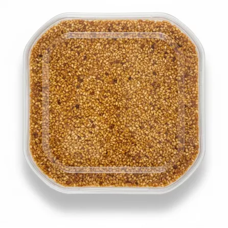 Top view of Anjoman Honey Konjed Sesame Sohan showing sesame seeds and honey blend