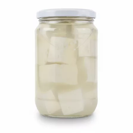Close-up of Akkawi cheese cubes in brine inside glass jar