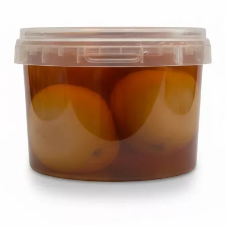 Side view of pickled lemons inside transparent container with brine
