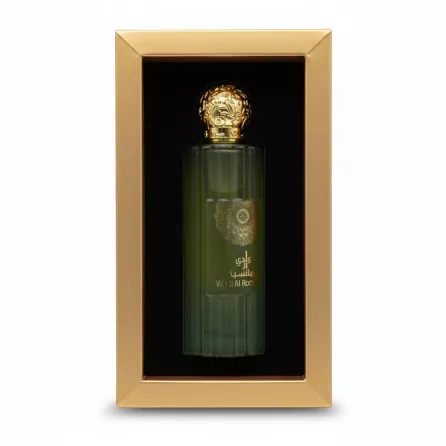Green frosted glass perfume bottle with gold embellished cap inside a presentation box