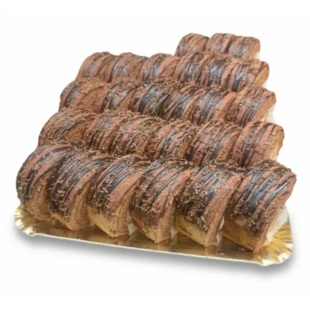 Tray of freshly made chocolate swirl cake rolls with chocolate drizzle and shavings