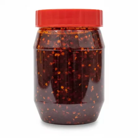Close-up view of extra hot chilli oil with visible chilli flakes inside jar