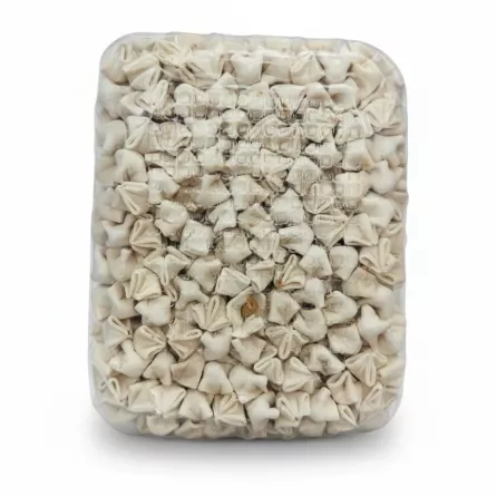 Close-up of fresh Kayseri manti pieces tightly packed inside clear plastic
