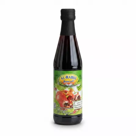 Bottle of Al-Rabih pomegranate molasses held in hand showing front label