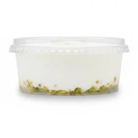 Side view of Tak brand white ice cream tub showing pistachio bits settled at the base inside a clear container