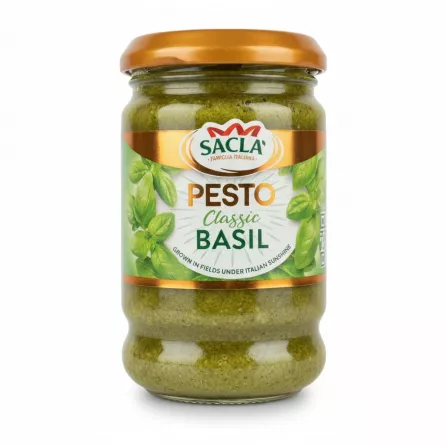 Jar of Sacla Classic Basil Pesto held by hand showing front label