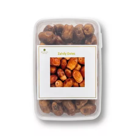 Enhanced A clear plastic container of Madina Zahdy Dates with a product label on top