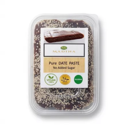 Enhanced Hand holding a container of Madina Pure Date Paste with sesame seeds and clear labelling for vegan, halal, and no added sugar