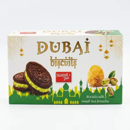 A professional 1:1 e-commerce photo of the Sweet Plus Dubai Pistachio Biscuits box. The box, which is clean and free of labels, is centered on a white background and lit with professional studio lighting. It features a decorative green and white design with illustrations of chocolate pistachio biscuits, kadatif, and a Dubai skyline motif.