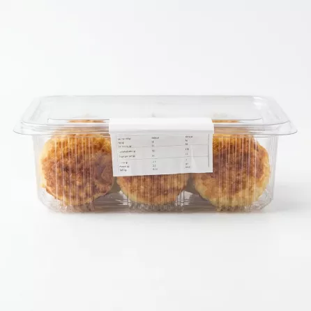 A clear plastic container of Dijla Food Coconut Maamoul pastries, showing three baked maamoul through the side with a white nutritional label. {image}