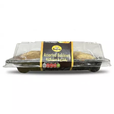 ** Side profile of a clear plastic package of Sofra Assorted Baklawa, featuring a black paper label with yellow and white text in English and Arabic. The package is set against a clean, plain white background.