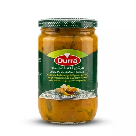 A 600g glass jar of Durra Amba Mixed Pickles with a green label and a spotted lid, shown in a front view against a clean white background. PRODUCT TITLE: Durra Amba Mixed Pickles PRODUCT: Durra Amba Mixed Pickles, 600g, front view jar, against a clean white background with professional studio lighting.