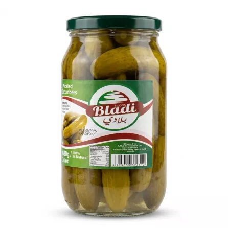 A 1:1 professional product photo of a Bladi Foods Pickled Cucumbers Jar (680g) with a green lid, filled with whole pickles. It features a clean label on a white studio background with a soft, symmetrical shadow.