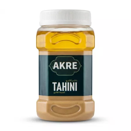 A 1700g plastic jar of AKRE Tahini, an authentic sesame spread, featuring its green and blue label, with a ribbed white cap, displayed on a clean white background with a soft, even shadow.