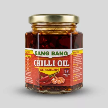 Enhanced Bang Bang Chilli Oil With Shrimps jar held in hand in grocery aisle
