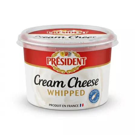 Enhanced Hand holding Président Whipped Cream Cheese tub in a grocery store