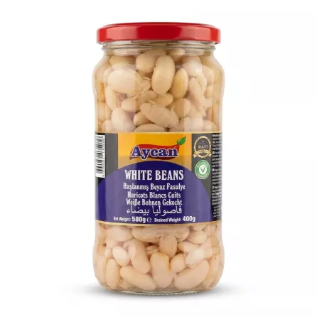 A 580g glass jar of Aycan white beans, featuring a red lid and clear glass. The blue label displays "Aycan," "WHITE BEANS," and translations in several languages, set against a seamless white background with a soft shadow.