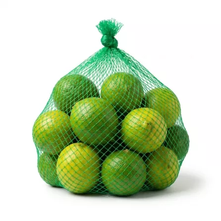 Enhanced Hand holding net bag filled with fresh limes in a grocery store