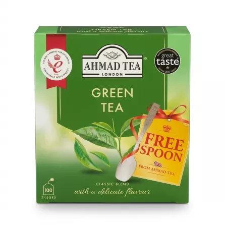 A 1:1 professional e-commerce product photograph of the Ahmad Tea Green Tea Classic Blend box, featuring 100 tagged bags and a 'FREE SPOON' promotion badge with an attached tea spoon. The green package displays the 'The King's Awards for Enterprise' and 'Great Taste 2023' awards against a clean white background with soft, even studio lighting.