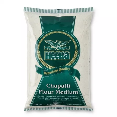 A 1.5kg bag of Heera Chapatti Flour Medium, featuring its distinctive green brand shield and logo, presented in a clean, professional studio setting.