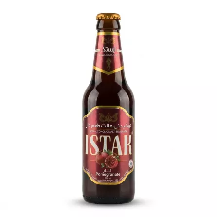 A 320ml glass bottle of Istak Pomegranate Non Alcoholic Malt Beverage is centered on a clean white background. It features a maroon and gold label with images of fresh pomegranates and the product name in large English and Arabic text.