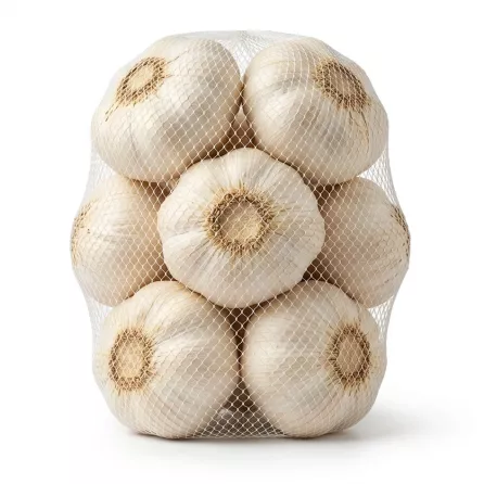 Enhanced Hand holding a mesh bag of whole garlic bulbs with Bravo branding