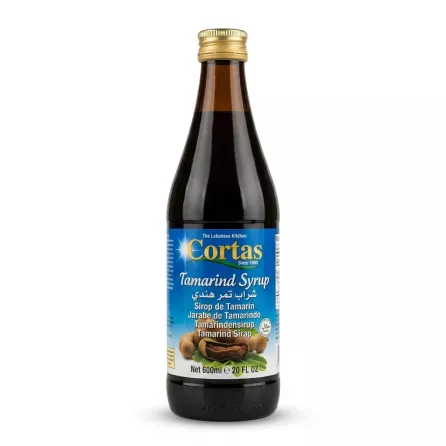 Enhanced Cortas Tamarind Syrup 600ml bottle with gold cap, held in hand in a grocery store aisle