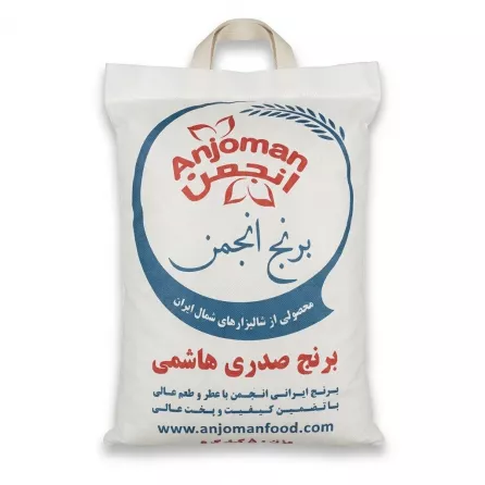 A centered, front-view professional studio photograph of a 5kg fabric bag of Anjoman Sadri Hashemi Rice. The white fabric bag features the 'Anjoman' logo in red within a circular motif, the product name in large blue and red Persian script ('برنج انجمن' and 'برنج صدری هاشمی'), descriptive Persian text regarding quality and origin, and the website 'www.anjomanfood.com'. The bag has a woven handle and sits on a pure white background with soft, even shadowing.
