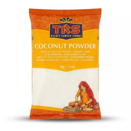 A 1kg plastic bag of TRS brand fine white Coconut Powder. The package has an orange top border with the brand logo and the product name "Coconut Powder" listed in multiple languages. Below, a clear window shows the product, alongside an illustration of a woman in traditional clothing processing coconuts. The bag is centered on a plain white background with professional studio lighting and soft, symmetrical shadows.