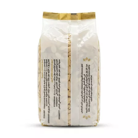 A centered, professional 1:1 square studio photograph of the back of a large plastic packet of Orouba Roasted Pumpkin Seeds. The white packaging features two clear vertical columns of Arabic text detailing product information and contact details, set against a seamless solid white background with soft studio lighting.