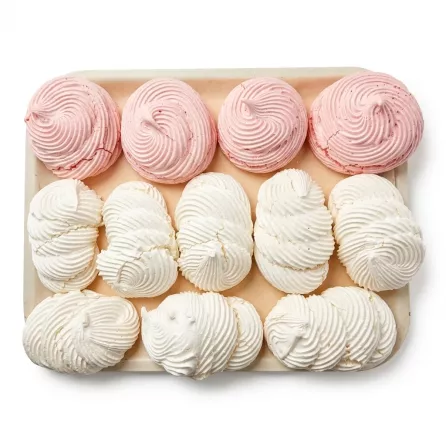 Tray of handmade white and pink meringue cookies with swirl design