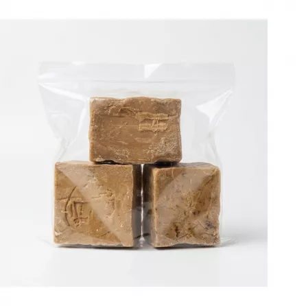 Three blocks of traditional raw African black soap in a clear plastic bag with a £5.00 label