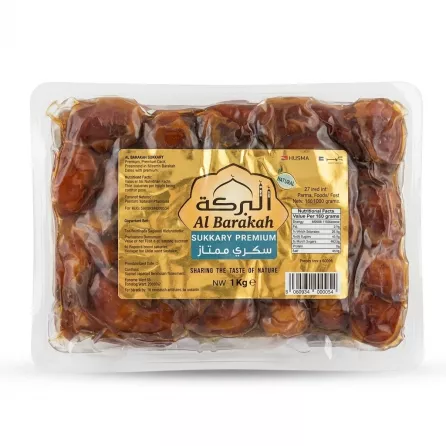 Front view of Al Barakah Sukkary Premium Dates 1kg pack held in hand showing the gold packaging and price label